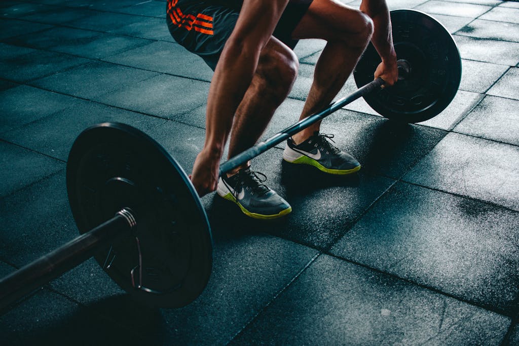 Man performing a deadlift exercise in a gym, demonstrating strength and fitness.