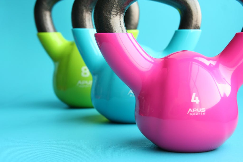 Vibrant colored kettlebells on blue background highlighting fitness and exercise equipment.